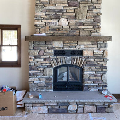 Grey limestone hearth with on a fireplace with a non-combustible mantel