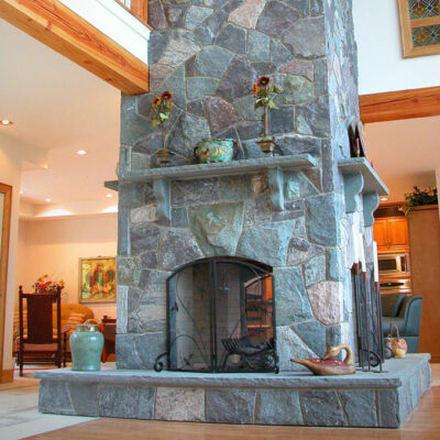 Tall fireplace with mosaic stone and bluestone hearth and bluestone mantel